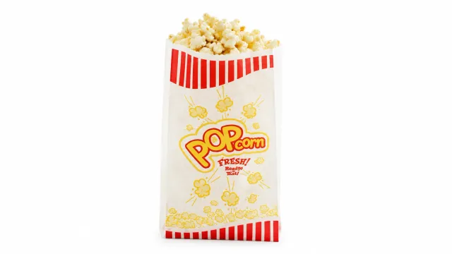 Red and white striped popcorn bag filled with buttered popcorn for carnival event rentals